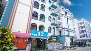 a large white building with a hotel pharmacy sign on it at Hotel Priyadarshini in Digha