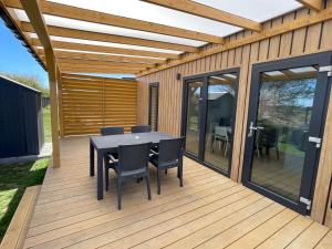 a patio with a table and chairs on a deck at Aura Baltic in Rewal