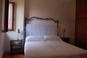 um quarto com uma cama com uma colcha branca em Casa dell'Oleandro em Torre Faro