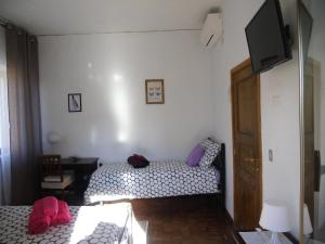 ナポリにあるCampi Flegrei Studiosのベッドルーム1室(ベッド2台、薄型テレビ付)