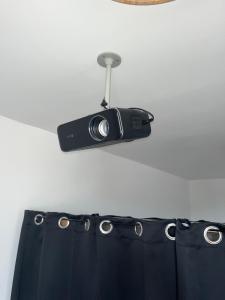 a camera hanging on a wall next to a black skirt at Le petit Vittel in Vittel