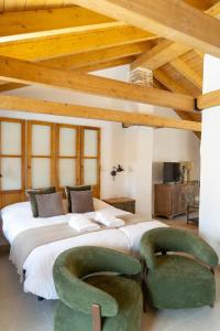 a bedroom with a large bed with green chairs at Casa Molivez Apartamento Fabregas in Alhama de Granada