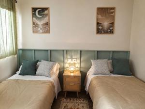 two beds sitting next to each other in a room at Casa río de Bolbaite in Bolbaite