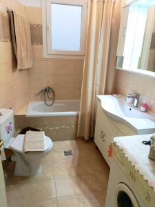 a bathroom with a toilet and a tub and a sink at Maira's place Corfu in Corfu +7 photos