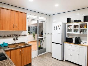 a kitchen with wooden cabinets and a white refrigerator at Casa río de Bolbaite in Bolbaite