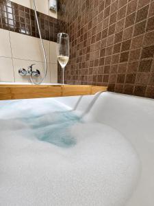 a bath tub with a glass of wine and a glass of water at Casa río de Bolbaite in Bolbaite +14 photos