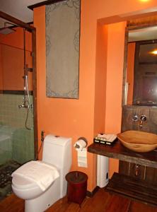 a bathroom with a toilet and a wooden sink at Haven Resort Paro in Paro