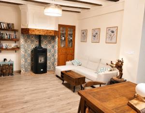 a living room with a white couch and a fireplace at Casa río de Bolbaite in Bolbaite