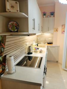 a kitchen with white cabinets and a stove top oven at Maira's place Corfu in Corfu