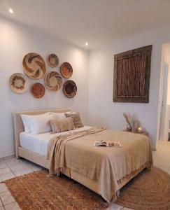 a bedroom with a bed with plates on the wall at Physis Oikos Beachfront Apartments in Skiathos