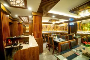 a restaurant with tables and chairs and a bar at Hotel Priyadarshini in Digha