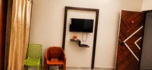a room with a tv and a chair and a mirror at Grand Ayushmaan - Best Hotel in Jabalpur in Jabalpur +13 photos