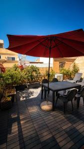 a table and chairs with an umbrella on a patio at Ensuite budget twin room at quiet and friendly townhouse in Sliema