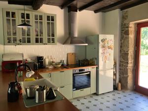 a kitchen with a white refrigerator and a sink at Casa do Mao in San Lorenzo de Barjacoba +5 photos