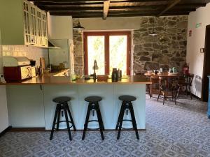 a kitchen with two bar stools and a counter top at Casa do Mao in San Lorenzo de Barjacoba