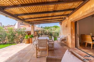 an outdoor patio with a wooden pergola at Villa Domo Mea - By Searly in Porto Cervo