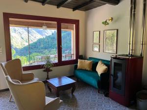 a living room with a green couch and a window at Casa do Mao in San Lorenzo de Barjacoba
