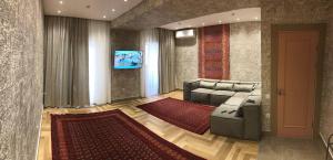 a living room with a couch and a television at Tashkent City View Apartments in Tashkent