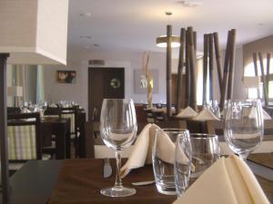 a table with wine glasses on top of it at Logis Hôtel Les 3B in Nouilhan