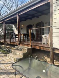 a wooden deck with a table and chairs on a house at This Is Us in Franschhoek