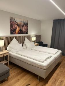 ein Schlafzimmer mit einem Bett, auf dem ein Bild eines Stiers hing. in der Unterkunft Landhotel Ewerts in Insul