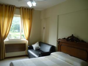 a bedroom with a bed and a chair and a window at Flats Cavalinho Branco 405 ou 603 in Águas de Lindóia +39 photos