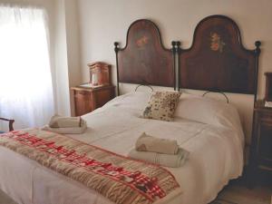 a large white bed with a large wooden headboard at Casa alla Rocca in Petritoli
