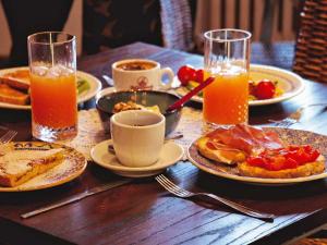 a wooden table topped with plates of food and orange juice at Casa alla Rocca in Petritoli