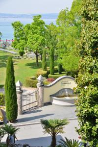 a garden with a fountain and trees and the ocean at Hotel Luna in Sirmione