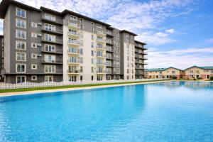 ein großes Schwimmbecken vor einem Gebäude in der Unterkunft Green Place #Cosmopolis #freeparking in Tunari + 6 Fotos