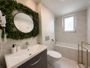 ein Badezimmer mit Waschbecken, Toilette und Spiegel in der Unterkunft Green Place #Cosmopolis #freeparking in Tunari