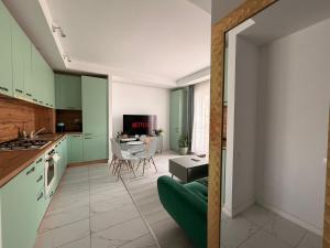 eine Küche mit grünen Schränken und ein Wohnzimmer in der Unterkunft Green Place #Cosmopolis #freeparking in Tunari