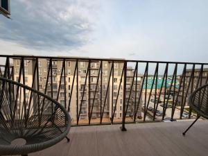 ein Balkon mit zwei Stühlen und ein Gebäude in der Unterkunft Green Place #Cosmopolis #freeparking in Tunari