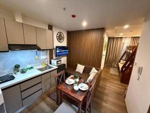 a kitchen and a living room with a table in a room at Bunker in Baguio