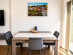 a dining room table with chairs and a painting on the wall at Aran View Holiday Homes - The Courtyard Suite - Cozy for two in Doolin +5 photos