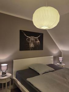 a bedroom with a bed with a picture of a bull at Muttis Haus Auf dem Felde 15 in Ummern
