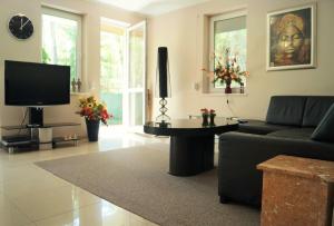 salon z kanapą i telewizorem w obiekcie Apartament Maria w mieście Międzyzdroje