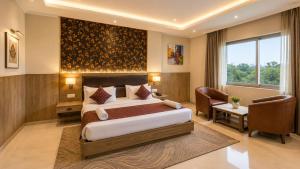 a bedroom with a bed and a desk and a window at Hotel Corporate Plaza Near Terminal 3 Delhi International Airport With Free Airport Pickup in New Delhi +13 photos