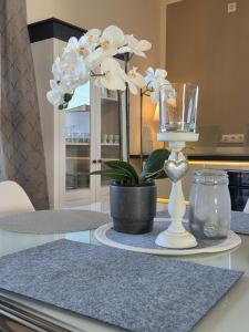 a table with a vase and a glass and flowers at Muttis Haus Auf dem Felde 15 in Ummern