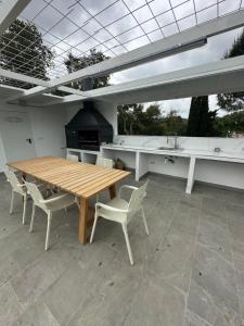 a patio with a wooden table and chairs and a stove at La jaima in Santa Ceclina