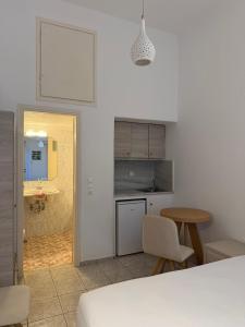a white kitchen with a table and a table and chairs at Romantika in Platis Gialos