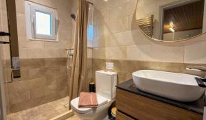 a bathroom with a sink and a toilet and a mirror at Zografia View in Corfu +16 photos