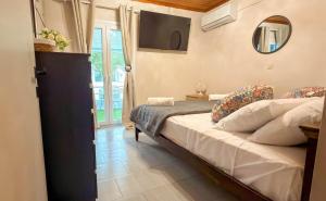 a bedroom with a bed and a television in a room at Zografia View in Corfu