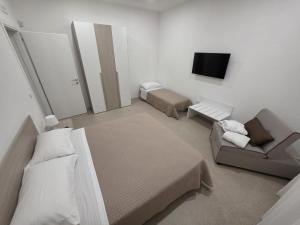 a bedroom with a bed and a couch and a tv at Piccola Chappy in Taranto