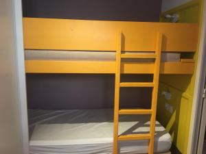 a yellow bunk bed with a ladder in a room at Location appartement proche Saint Tropez in Roquebrune-sur-Argens +22 photos