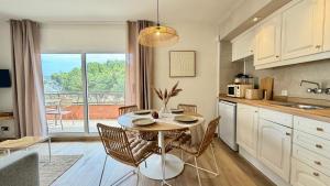 a kitchen with a table with chairs and a table at Salles Beach 33 in L'Estartit