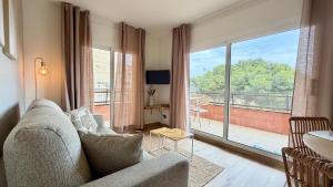 a living room with a couch and a large window at Salles Beach 33 in L'Estartit