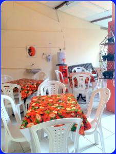 a dining room with white tables and white chairs at Hospedaria Praia e Sol in Fortaleza