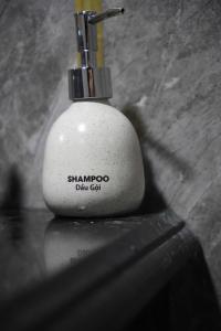 a white soap dispenser sitting on top of a counter at Old Village House in Yên Bài