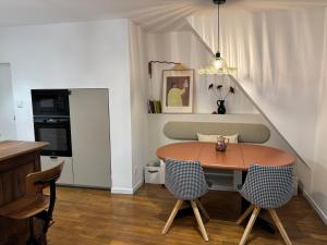 a dining room with a table and two chairs at Nid d argile - appartement neuf - 650m des Thermes - 1er étage in Salins-les-Bains
